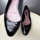 Embossed Louis Vuitton Paris logo on black patent leather ballet flat.